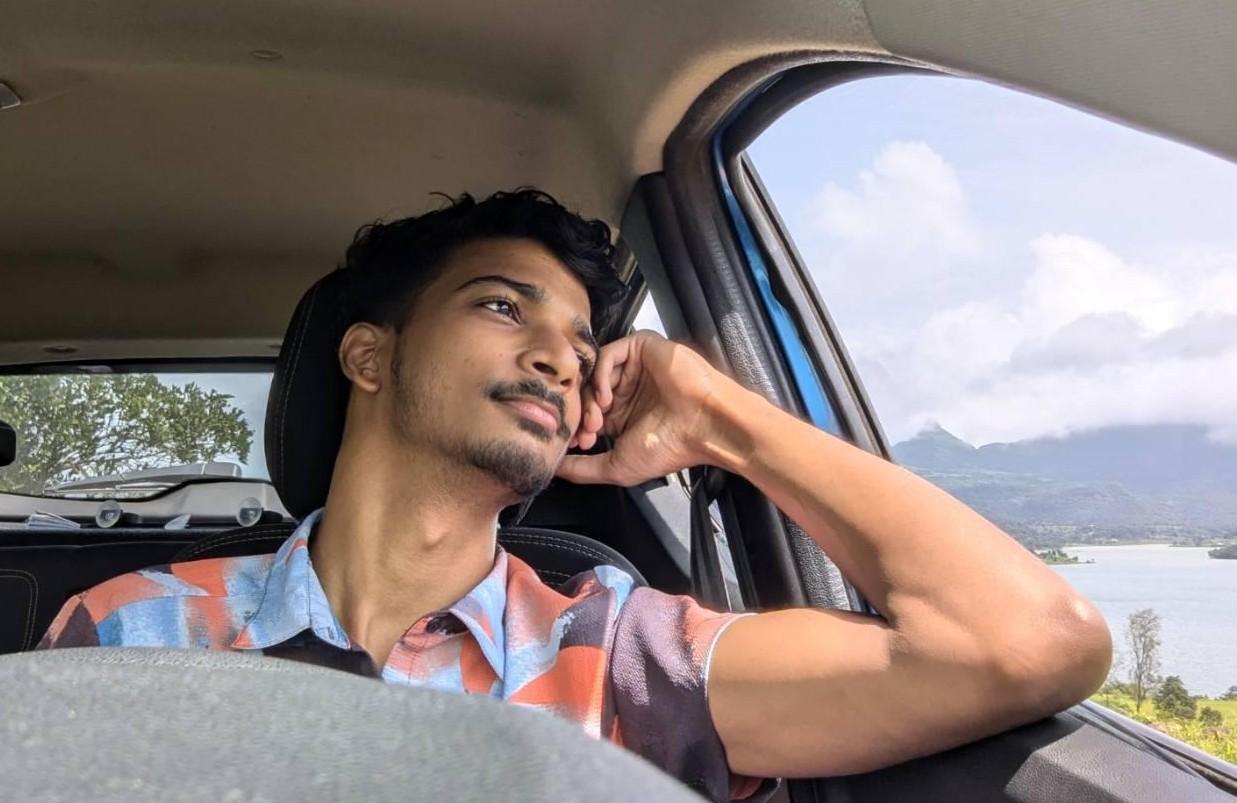 Pranav Chakkarwar in a standing car looking out the window, admiring nature